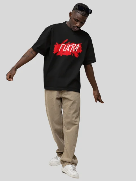 A man showcases an oversized black t-shirt that boldly displays the word "fukra" in a stylish design.