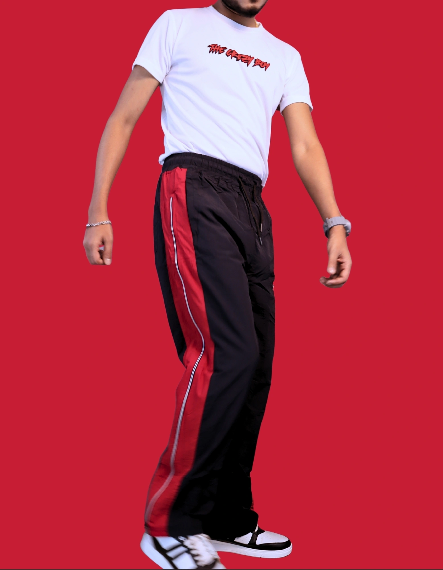 "Back view of colorblock track pants showing secure zipper pocket on red panel"